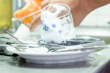 Bulaşıkları deterjan köpüğüyle yıkıyorum.