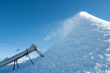 Snowmaking using a snowgun to produce artificial snow clipart