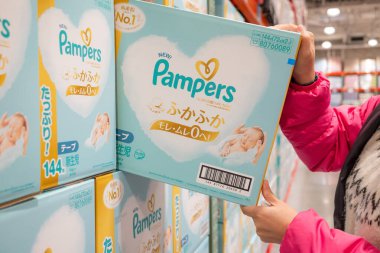 Alışverişçinin biri marketin rafından bir kutu bez alır.