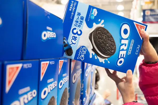 Alışverişçinin biri marketin rafından bir kutu Oreo kurabiyesi alır.