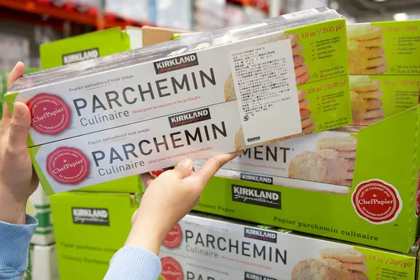 Costco 'da Kirkland Parchemin Mutfak Parşömeni Kağıtları' nı tutan eller.