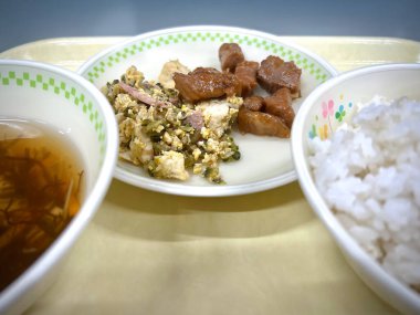 Goya champuru (soya peyniri ve yumurta ile kavrulmuş kavun kızartması) ve rafute (domuz buğulaması) gibi Okinawa 'nın yerli gıdalarını içeren Japon yemek tepsisi.).