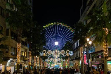 Vigo, İspanya - 05 Aralık 2022: Noel ışıkları dekorasyonunda dev dönme dolap, Vigo, Pontevedra, İspanya 'da turistler geziyor.