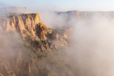 clay ravines, covered in fog, called the barrancas del burujon in Toledo, Spain clipart