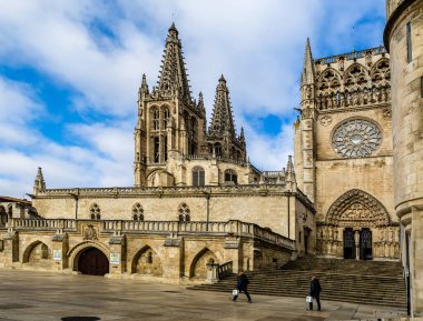 Burgos Cathedral with people and tourists walking past in the square next to the Cathedral of Saint Mary, in Burgos, Spain