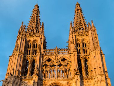 Burgos Cathedral with people and tourists walking past in the square next to the Cathedral of Saint Mary, in Burgos, Spain