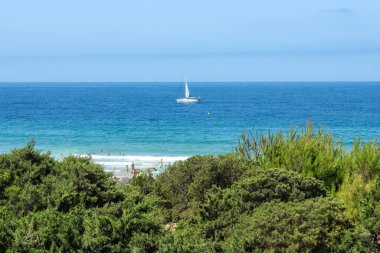 pleasure boat passing in front of the beach of La Barrosa, Cadiz, Spain