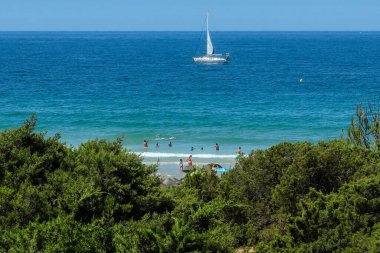 pleasure boat passing in front of the beach of La Barrosa, Cadiz, Spain