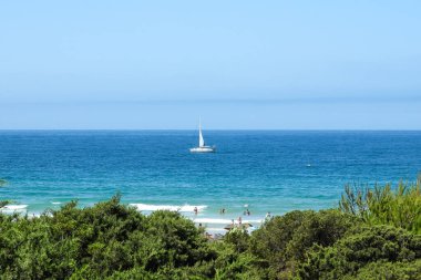 pleasure boat passing in front of the beach of La Barrosa, Cadiz, Spain