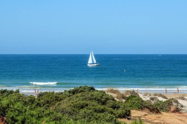 pleasure boat passing in front of the beach of La Barrosa, Cadiz, Spain