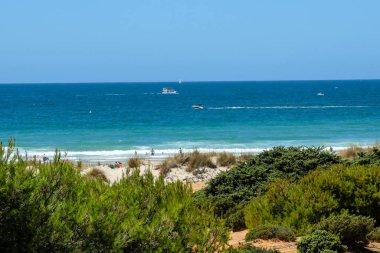 pleasure boat passing in front of the beach of La Barrosa, Cadiz, Spain