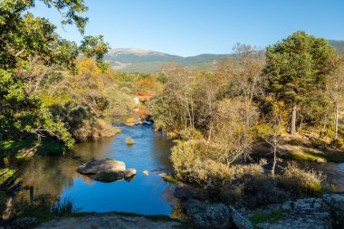İspanya 'nın Madrid eyaletindeki Sierra de Guadarrama' dan geçen sonbahar renkleriyle Lozoya nehri.
