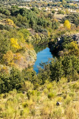İspanya 'nın Madrid eyaletindeki Sierra de Guadarrama' dan geçen sonbahar renkleriyle Lozoya nehri.