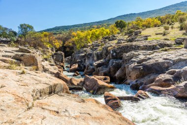 İspanya 'nın Madrid eyaletindeki Sierra de Guadarrama' dan geçen sonbahar renkleriyle Lozoya nehri.