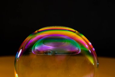 Gökkuşağı sabun köpüğü karanlık bir arka plan üzerinde.