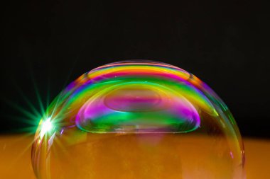 Gökkuşağı sabun köpüğü karanlık bir arka plan üzerinde.