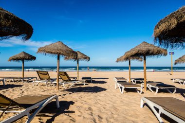 Parasols and hammocks on La Barrosa beach in Sancti Petri, Cadiz, Spain