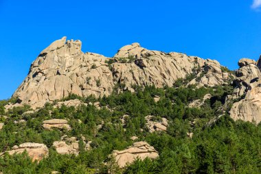 Pedriza Bölgesel Parkı 'ndaki dağları izleyen bir çocuğun panoramik görüntüsü.