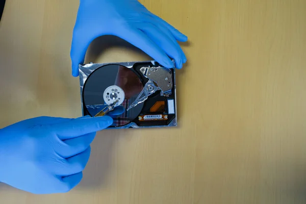 a technician fixes a computer hard drive in a workshop
