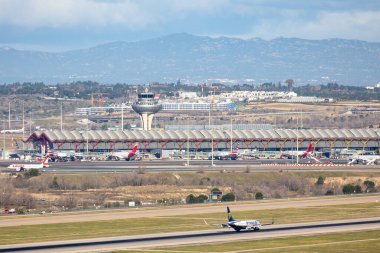 Madrid, İspanya - 14 Mart 2023: Adolfo Suarez Madrid Barajas Havalimanı 'na iniş yapan uçaklar Madrid, İspanya' da arka planda şehir silüeti bulunmaktadır.