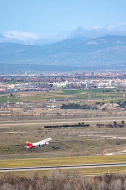 Madrid, İspanya - 14 Mart 2023: Adolfo Suarez Madrid Barajas Havaalanı 'ndan kalkan uçaklar Madrid, İspanya' nın arka planında şehir silüeti ile birlikte