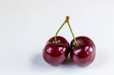 Olgun kiraz yığınını yaprak ve saplarla kapatın. Büyük bir taze kırmızı kiraz koleksiyonu. Olgun kiraz arkaplanı.