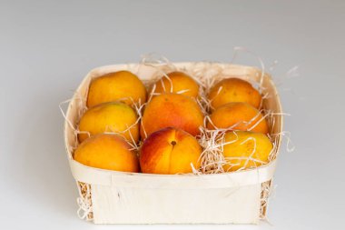 Masanın üzerindeki ahşap kasede lezzetli olgun kayısılar. Yukarıdan yatay görünüm