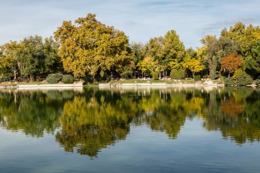 Lake of the Casa de Campo park with autumn colored trees in Madrid