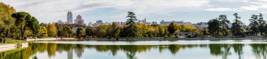 Lake of the Casa de Campo park with autumn colored trees in Madrid