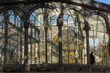İspanya, Madrid 'de sonbahar renkleriyle El Retiro halk parkında Palacio de Cristal adlı sergi merkezi