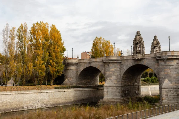 马德里河地区的托莱多桥 树上长满了秋天的色彩 — 图库照片