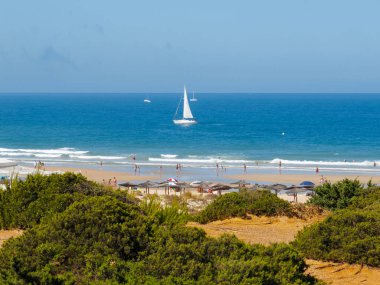 pleasure boats passing in front of La Barrosa beach in Sancti Petri Cadiz