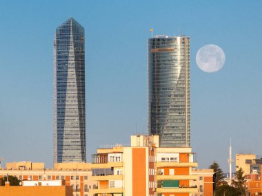 The moon over the four towers in the city of Madrid, Spain