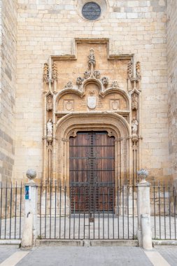 Alcala de Henares - 5 Mayıs 2025: Katedralin ana cephesi, İspanya 'nın Alcala de Henares kentinin tarihi merkezine girmek için bekleyen ziyaretçilerle birlikte