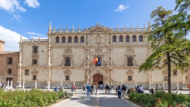 Alcala de Henares - 5 Mayıs 2025: Üniversitenin ana cephesi, İspanya 'nın Alcala de Henares kentinin tarihi merkezine girmek için bekleyen ziyaretçilerle birlikte