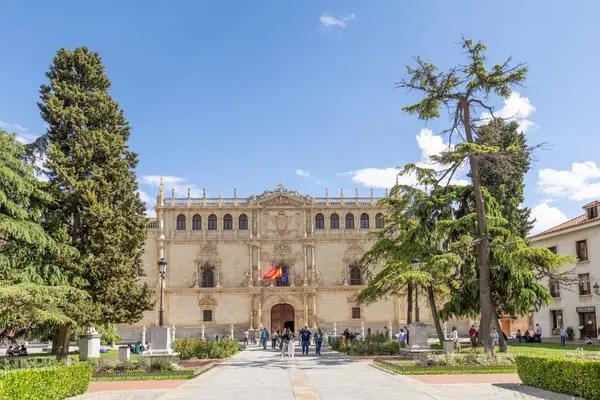 Alcala de Henares - 5 Mayıs 2025: Üniversitenin ana cephesi, İspanya 'nın Alcala de Henares kentinin tarihi merkezine girmek için bekleyen ziyaretçilerle birlikte