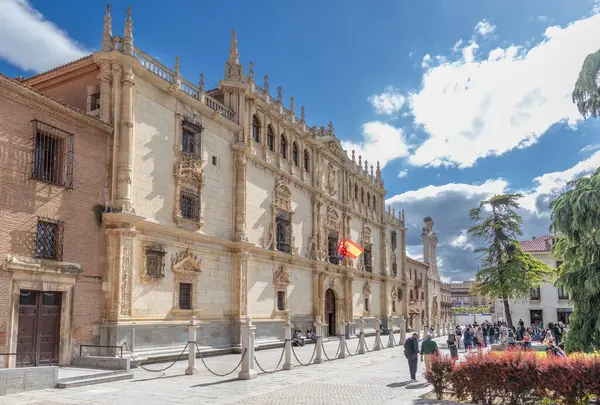 Alcala de Henares - 5 Mayıs 2025: Üniversitenin ana cephesi, İspanya 'nın Alcala de Henares kentinin tarihi merkezine girmek için bekleyen ziyaretçilerle birlikte