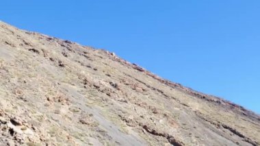 Gerçek 4K kamera görüntüleri volkanik kayalık dağın üzerinden yavaşça geçiyor, belgesel çekimlerinde etrafta kimse yok.