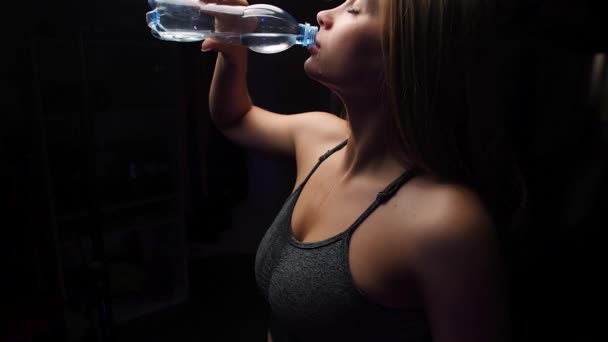 ジムでボトルから水を飲む美しい若いスポーツ女性 — ストック動画