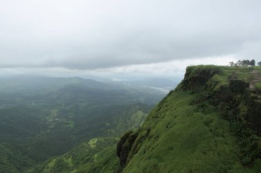Güzel, yemyeşil Sahyadri Dağları 'ndaki Sinhgad Kalesi' nin güçlü çevre duvarının panoramik manzarası. Sinhgad kalesi Pune, Maharashtra, Hindistan 'da ünlü bir turistik yerdir.