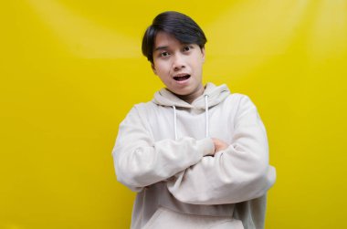 Mutlu, gülümseyen ve bej kapüşonlu, gülen Asyalı adam. Model reklamcılığı için en iyisi..