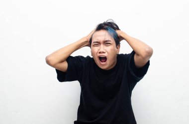 Hüsrana uğramış genç Asyalı adam sarı arka planda 