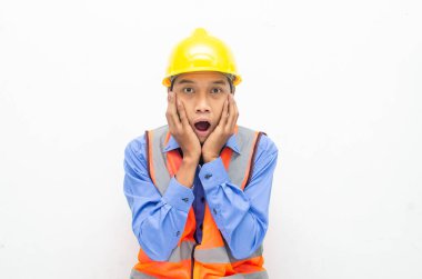 Korkak Asyalı inşaat işçisi sarı güvenlik kaskı ve yeleği giyiyor. 