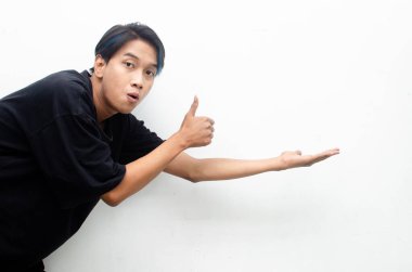 Stüdyonun arka planında genç Asyalı adam iyi niyet gösterisi yapıyor. 