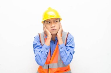 Sarı güvenlik kaskı ve yelek giyen Asyalı duygusal inşaat işçisi 