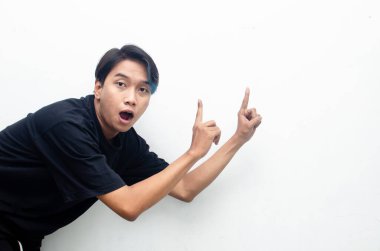 Neşeli genç Asyalı adam işaret ediyor 