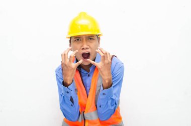 Sarı güvenlik kaskı ve yelek giyen Asyalı duygusal inşaat işçisi 