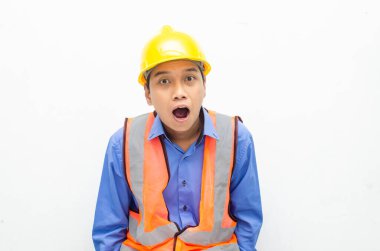 Korkak Asyalı inşaat işçisi sarı güvenlik kaskı ve yeleği giyiyor. 