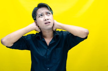 Sarı arka planda genç Asyalı bir adam 