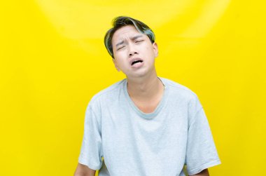 üzgün Asyalı genç adam stüdyo arka planında 